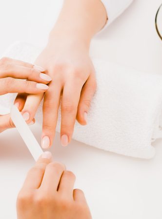 Cropped view of manicurist filing nails with nail file